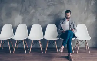 A man sitting in a chair reading a document